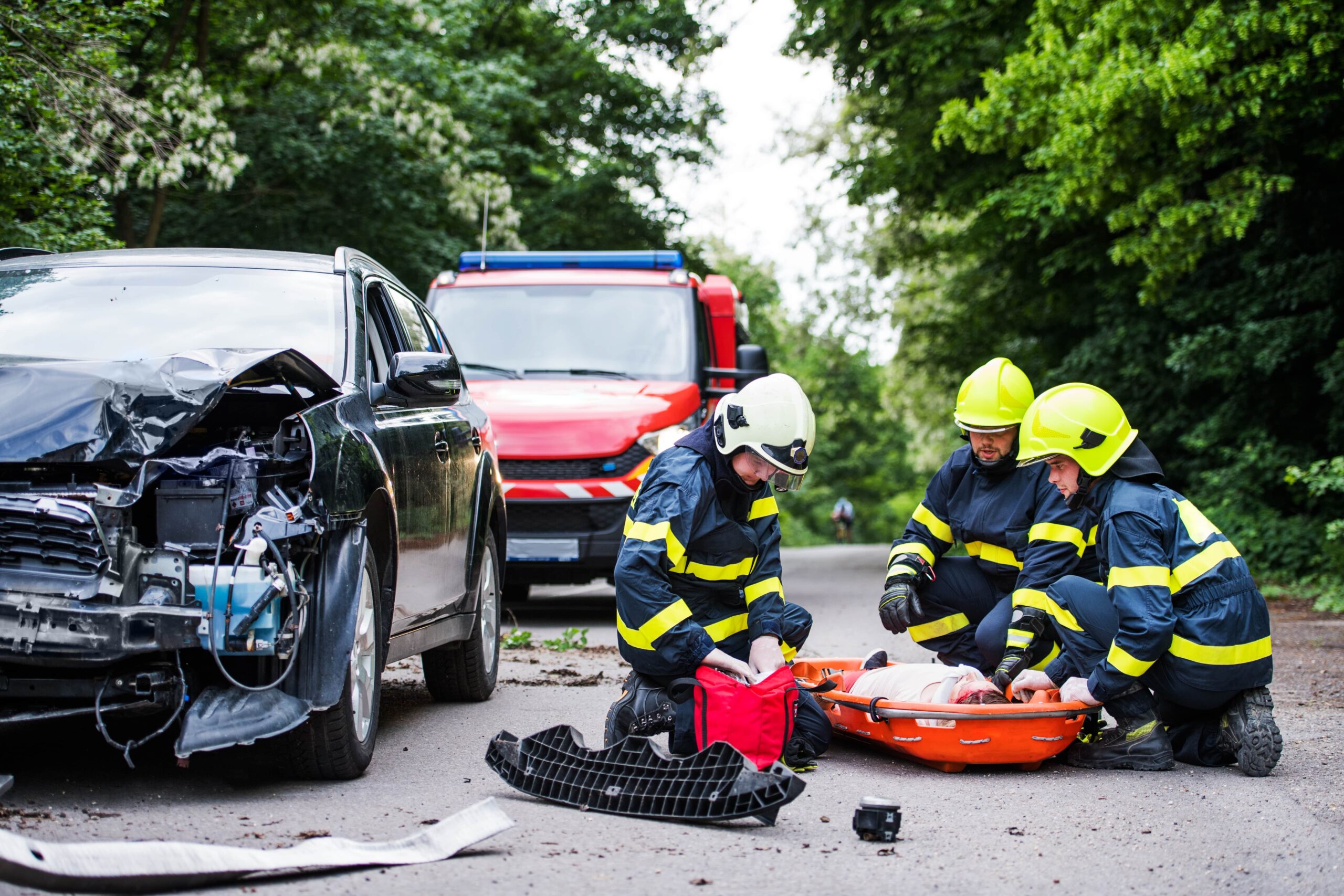 Firefighters assisting an injured woman after a car accident.