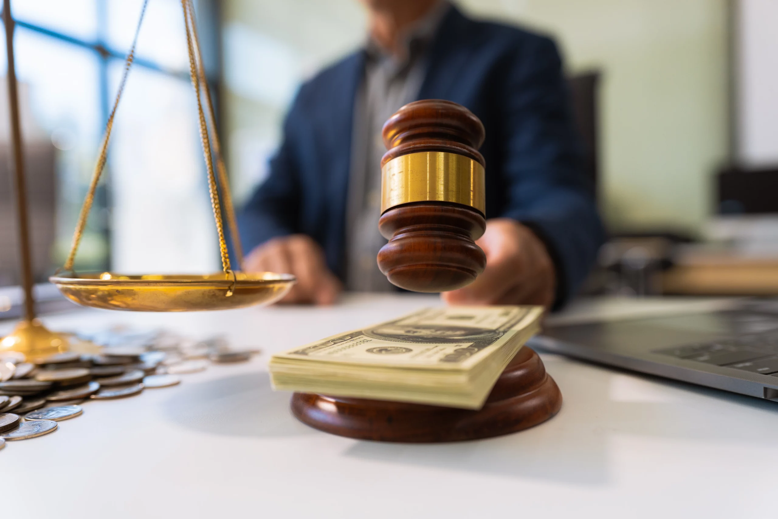 Judge’s gavel beside a stack of cash with scales of justice and coins on a desk, illustrating legal fees, contingency-based personal injury lawyer costs, and financial aspects of New Jersey injury claims.